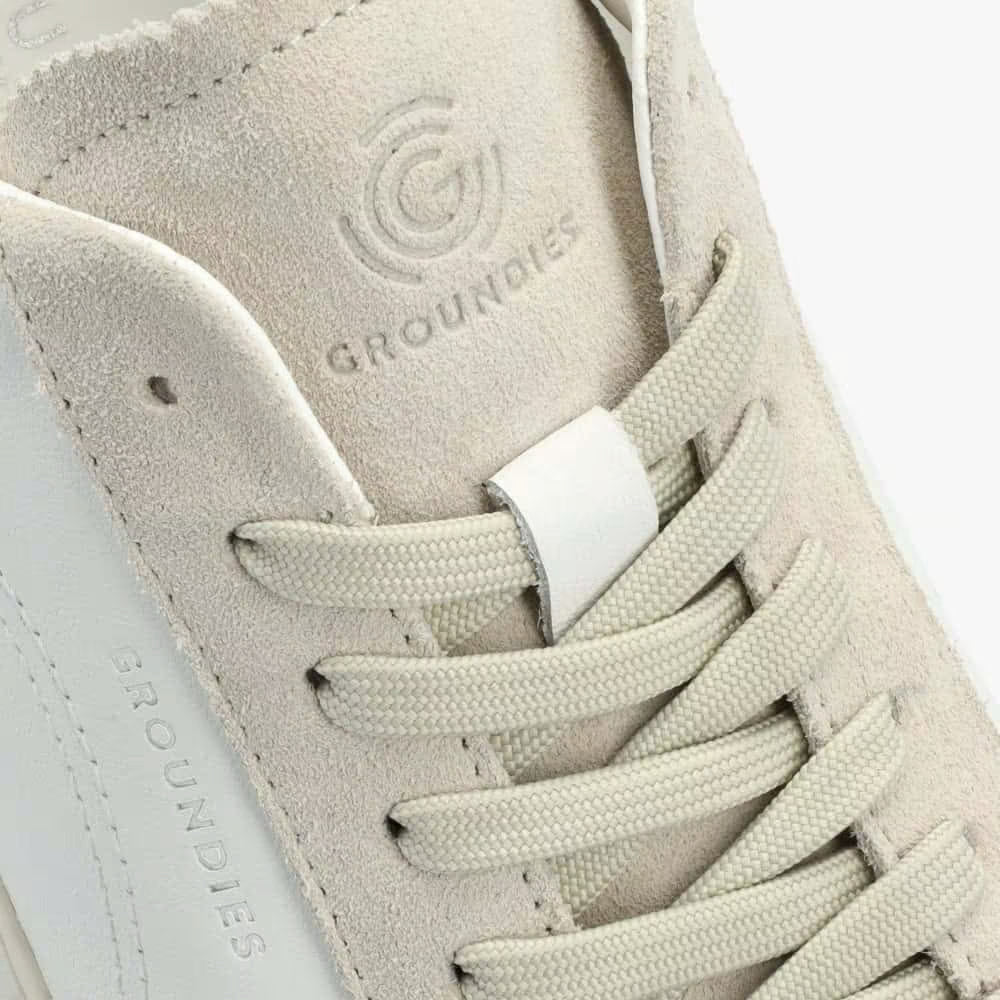 Close-up of a beige sneaker with 'Groundies' branding on a white background